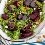 Pinterest graphic for Beet Salad recipe. Image shows a platter of Beet Salad garnished with goat cheese and walnuts. Text says, "Beet Salad simplejoy.com."