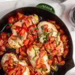 Pinterest graphic for Bruschetta Chicken recipe. Text says, "the best Bruschetta Chicken simplejoy.com." Image is overhead view of a skillet of Bruschetta Chicken with tomatoes beside.