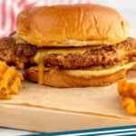 Pinterest graphic for Chicken Sandwich recipe. Image shows side view of Chicken Sandwich served on a bun with chick fil a sauce. Text says, "Chicken Sandwich simplejoy.com."