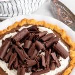 Pinterest graphic for Chocolate Cream Pie recipe. Text says, "the best Chocolate Cream Pie simplejoy.com." Image shows Chocolate Cream Pie garnished with whipped cream and chocolate shavings, with a serving spatula beside.