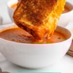 Pinterest graphic for grilled cheese sandwich recipe. Image is side view of person's hand dipping half of grilled cheese sandwich into a bowl of tomato soup. Text says, "super easy grilled cheese simplejoy.com."