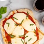 Pinterest graphic for Grilled Pizza recipe. Text says, "the best Grilled Pizza simplejoy.com." Image is overhead view of Grilled Pizza garnished with shredded basil and glass of red wine beside.