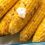 Pinterest graphic for Grilled Corn recipe. Image shows Grilled Corn with butter. Text says, "Grilled Corn simplejoy.com."