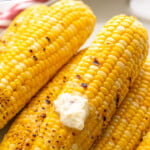 Pinterest graphic for Grilled Corn recipe. Text says, "How to: Grill Corn on the Cob simplejoy.com." Image shows Grilled Corn with butter.