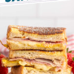 Pinterest graphic for Monte Cristo Sandwich recipe. Text says, "the best Monte Cristo Sandwich simplejoy.com." Image shows Monte Cristo Sandwiches cut in half and stacked on top of each other on a plate with strawberries.