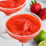 Pinterest graphic for Strawberry Margarita recipe. Text says, "the best Strawberry Margarita simplejoy.com." Image shows Strawberry Margarita served in a glass with a salted rim, strawberries and limes beside.