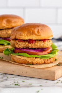 Side view of Air Fryer Turkey Burgers served on buns with lettuce, tomato, and onions.