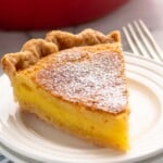 Slice of Chess Pie on a plate with a fork beside.