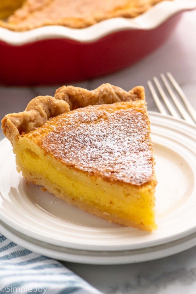 Slice of Chess Pie on a plate with a fork beside.