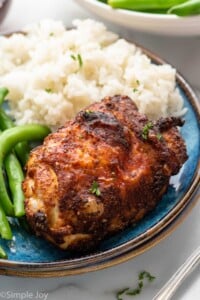 Air Fryer Chicken Thigh served on a plate with rice and green beans.