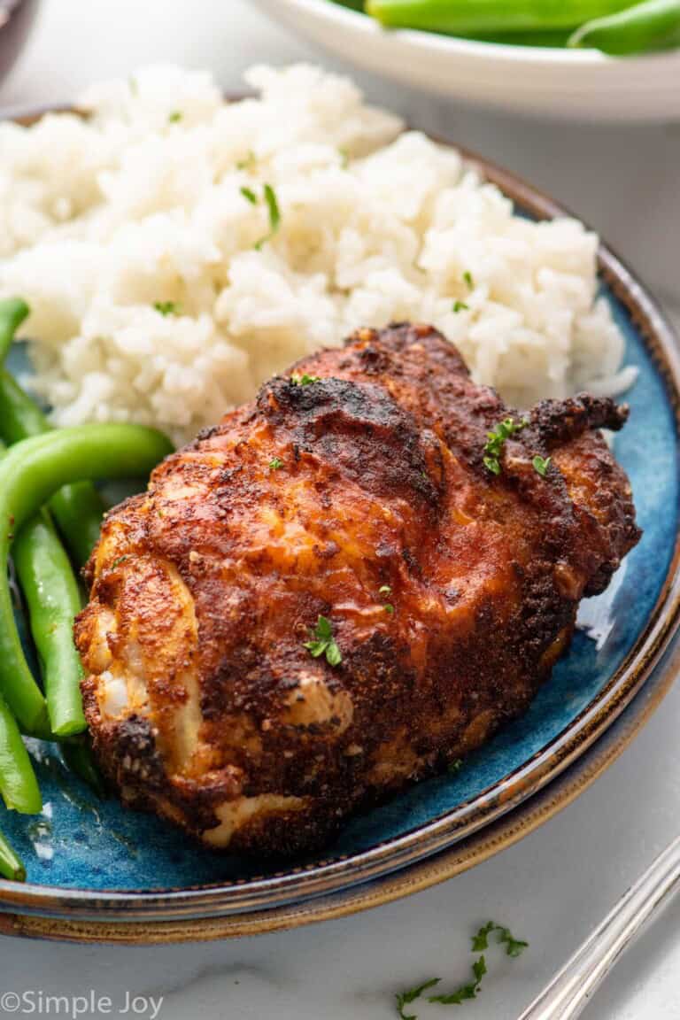 Air Fryer Chicken Thigh served on a plate with rice and green beans.