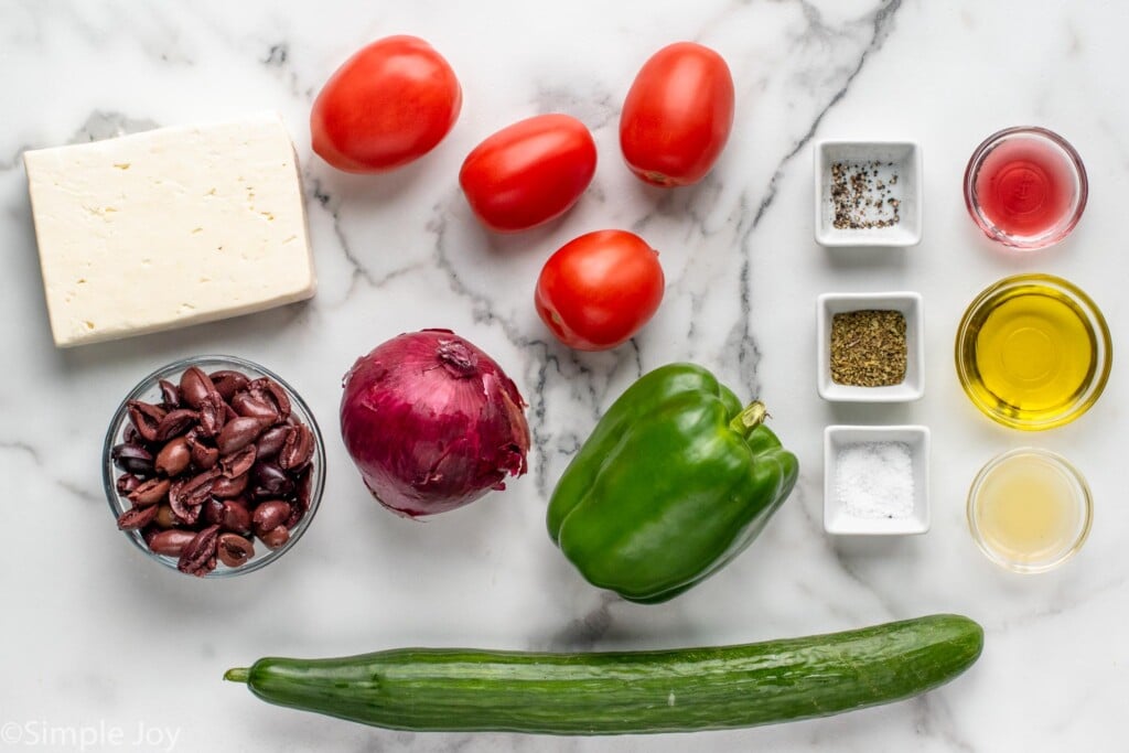 Overhead view of ingredients for Greek Salad recipe on countertop.