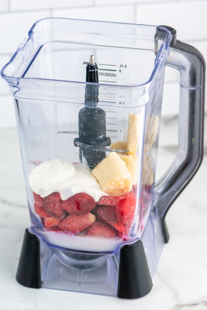 Blender with ingredients for Strawberry Banana Smoothie recipe.