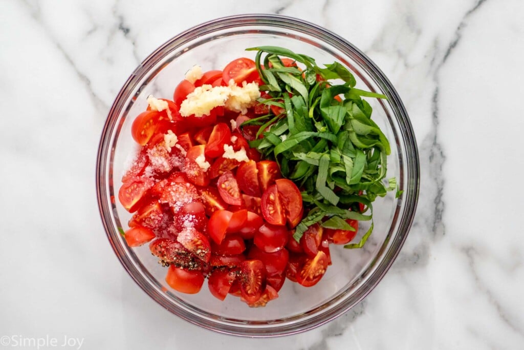 Overhead view of mixing bowl of ingredients for Bruschetta topping for Bruschetta Chicken recipe.