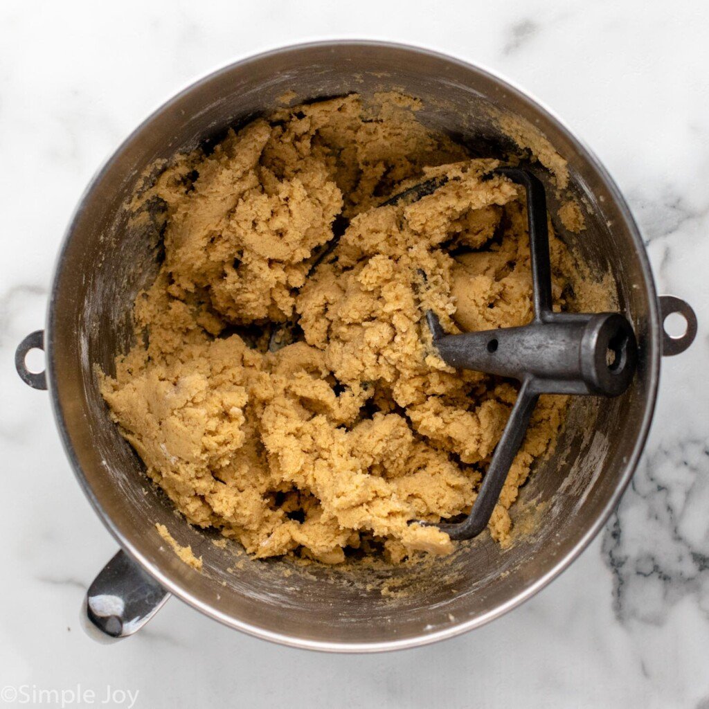 overhead of mixing bowl Chocolate Chip Cookie Bars ingredients and mixer attachment