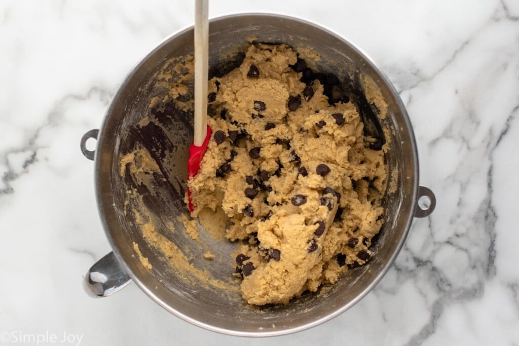 overhead of mixing bowl Chocolate Chip Cookie Bars ingredients and spatula