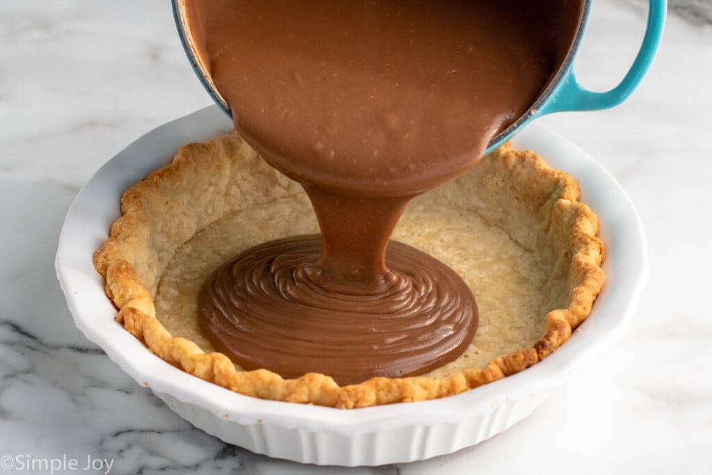 Pan of chocolate sauce being poured into a pie crust for Chocolate Cream Pie recipe