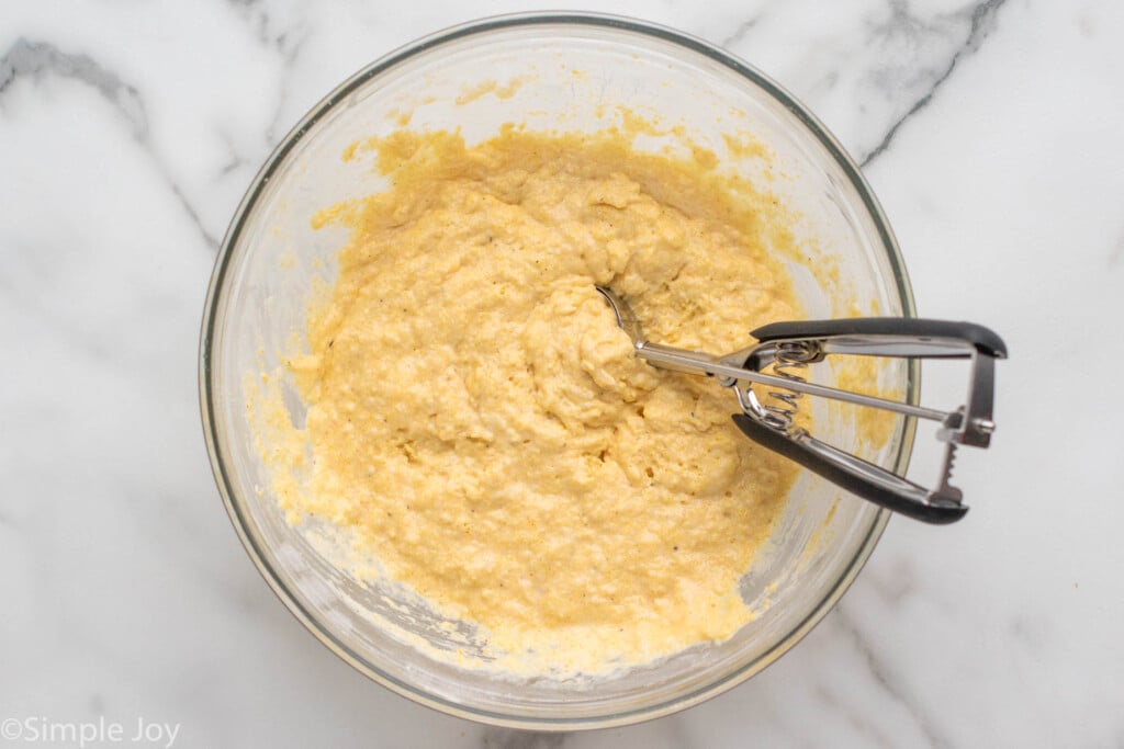 Mixing bowl of dough for Hush Puppies with cookie scooper.