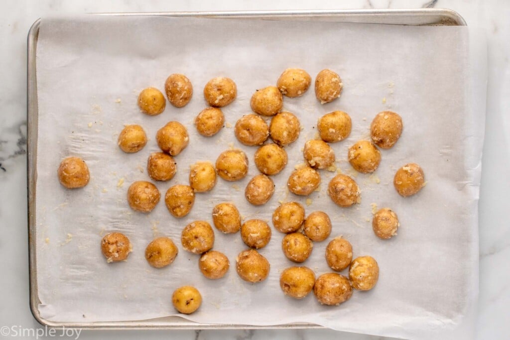 overhead of lined baking sheet with baby potatoes for baking
