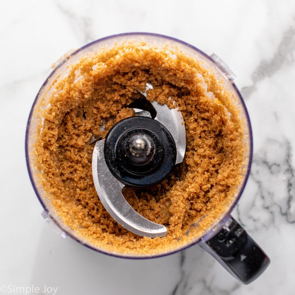 Overhead view of a food processor with graham crumbs for Strawberry Cheesecake recipe.