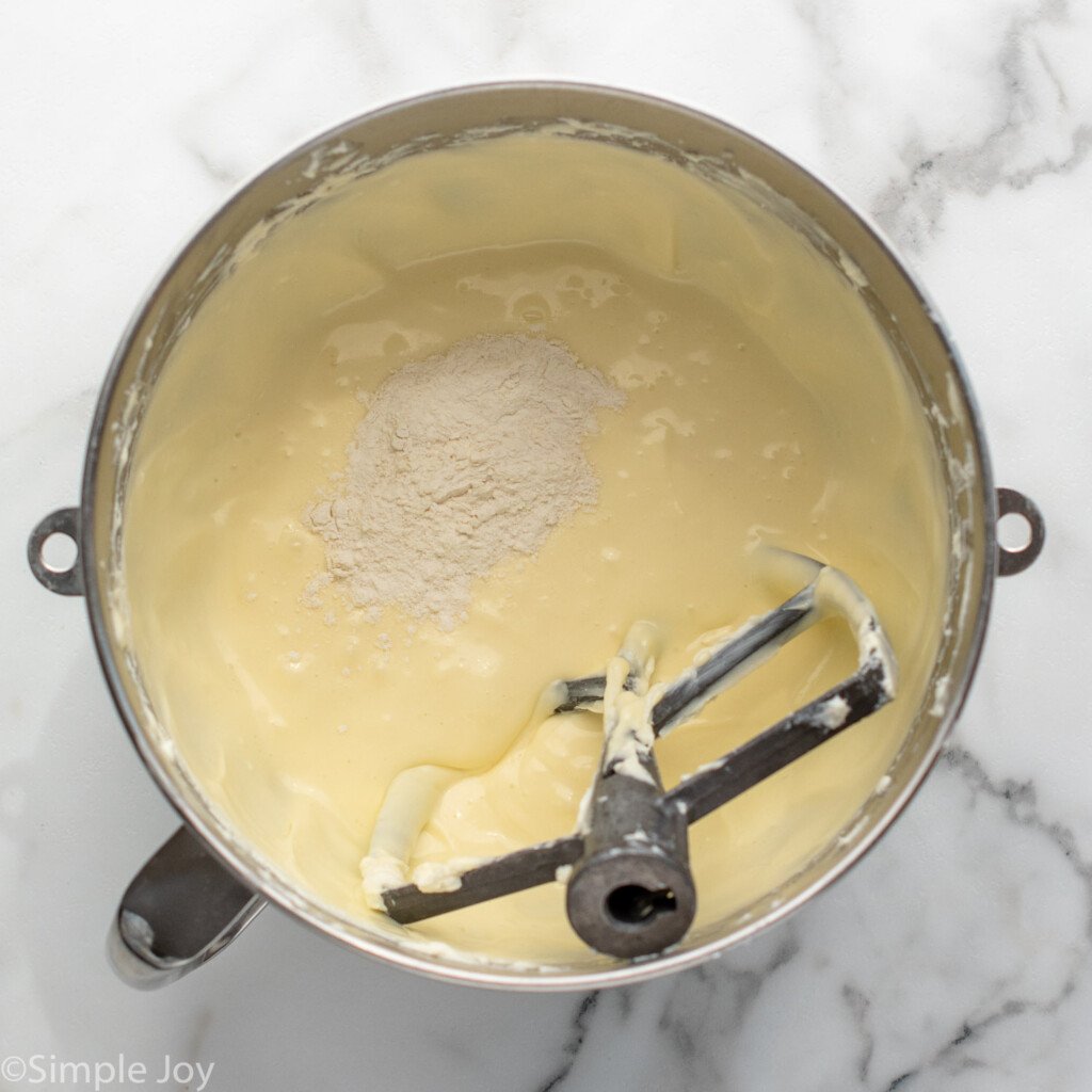 Overhead view of mixing bowl and beaters with cream cheese mixture for Strawberry Cheesecake recipe.