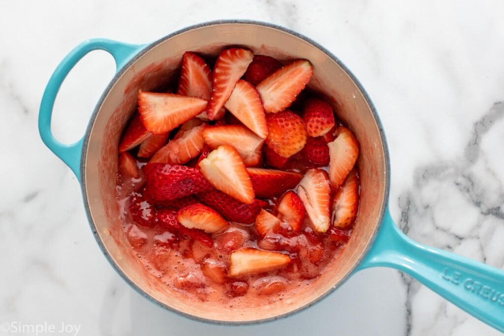 Overhead view of a pot with strawberry topping for Strawberry Cheesecake recipe.