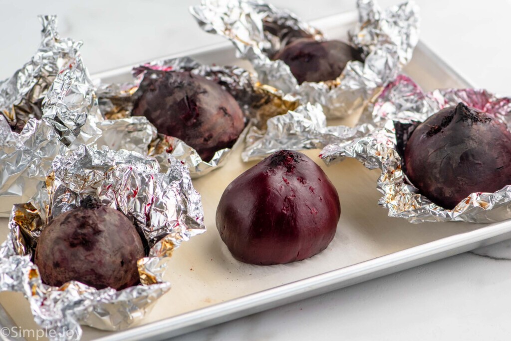 Roasted beets in foil on baking sheet for Beet Salad recipe.