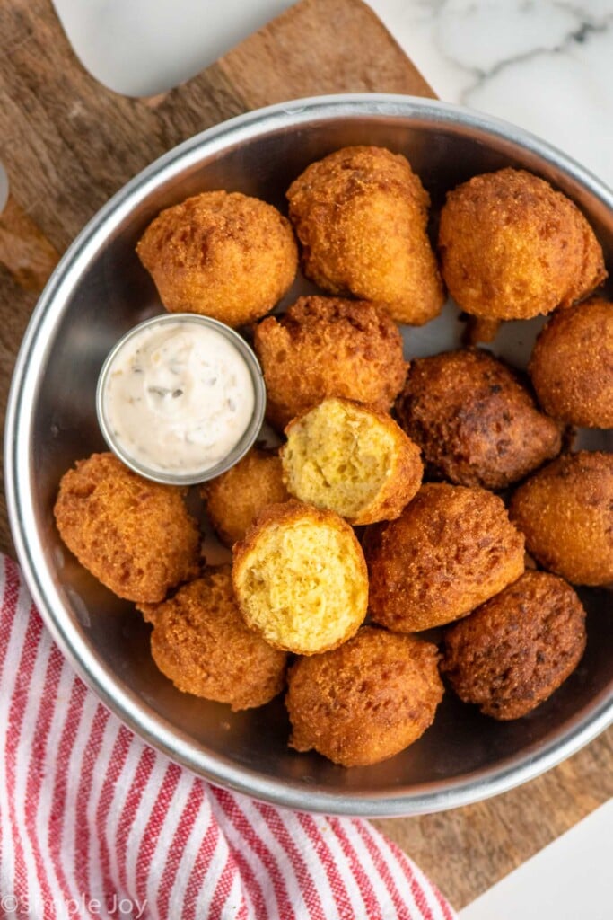 Overhead view of bowl of Hush Puppies with dipping sauce.