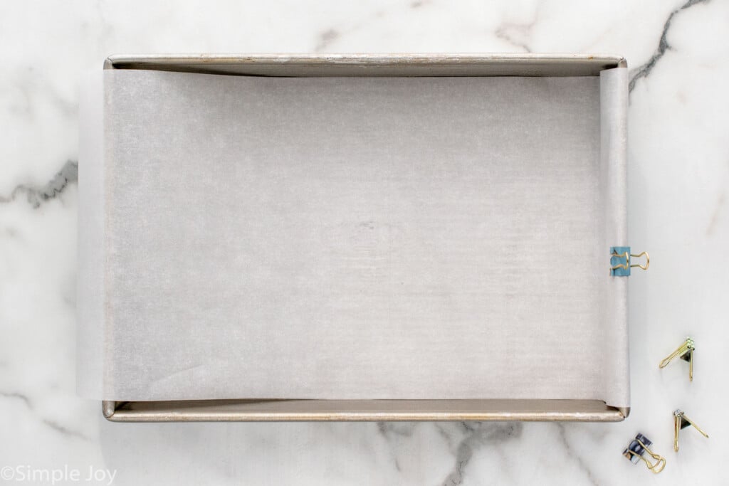 overhead of baking pan lined with parchment paper to make Chocolate Chip Cookie Bars