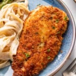 Parmesan Crusted Chicken on a plate next to pasta and asparagus