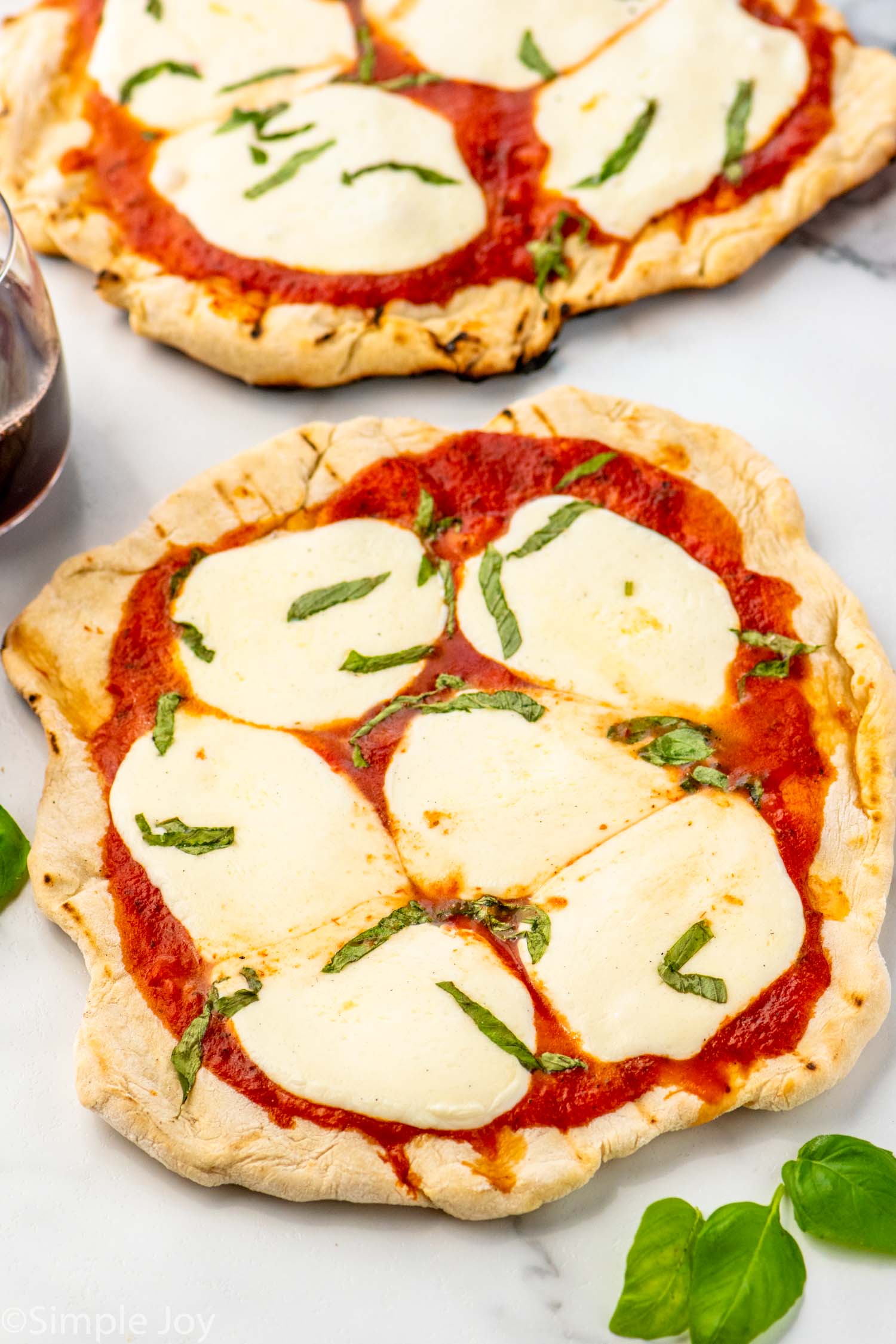 Overhead view of Grilled Pizza with cheese and basil.