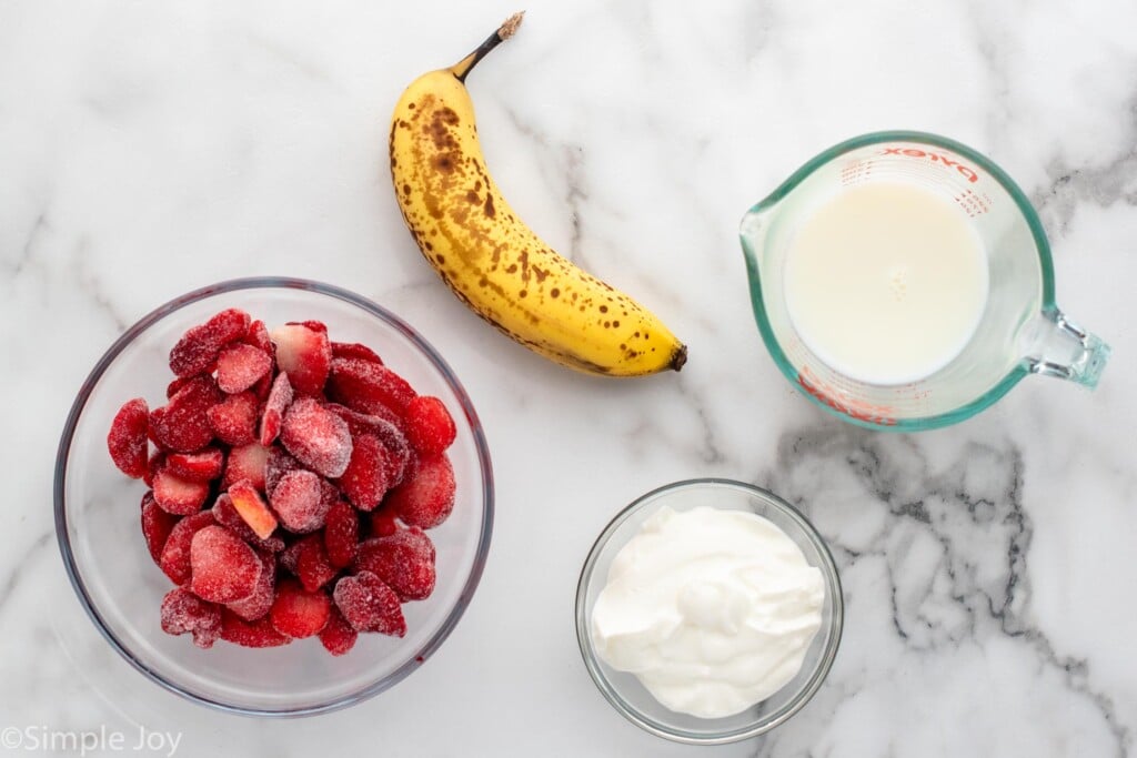 Overhead view of ingredients for Strawberry Banana Smoothie recipe on countertop.