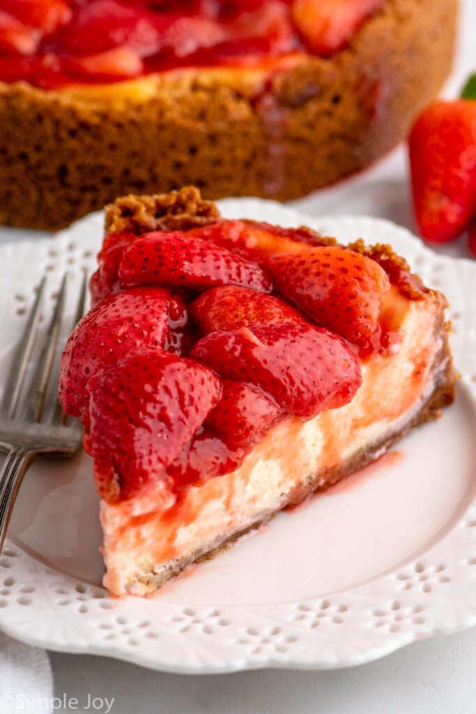 Slice of Strawberry Cheesecake served on a plate with a fork.