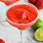 Strawberry Margarita with salted rim. Limes and strawberries beside. - 9