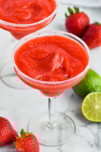 Strawberry Margarita with salted rim. Limes and strawberries beside. - 8