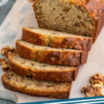 Pinterest graphic for Banana Nut Bread recipe. Image shows a partially sliced loaf of Banana Nut Bread recipe on a cutting board with walnuts. Text says, "Banana Nut Bread simplejoy.com"