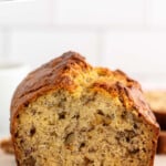 Pinterest graphic for Banana Nut Bread recipe. Text says, "the best Banana Nut Bread simplejoy.com." Image shows the front view of a loaf with a piece cut off, walnuts on cutting board beside.
