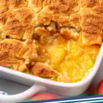 Pinterest graphic for peach cobbler recipe. Image shows a baking dish of peach cobbler with one piece removed. Text says, "peach cobbler simplejoy.com."