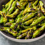 Pinterest graphic for shishito peppers recipe. Image shows a skillet of shishito peppers garnished with salt. Text says, "the best shishito peppers simplejoy.com."