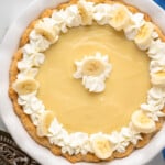Overhead view of Banana Cream Pie garnished with whipped cream and slices of banana