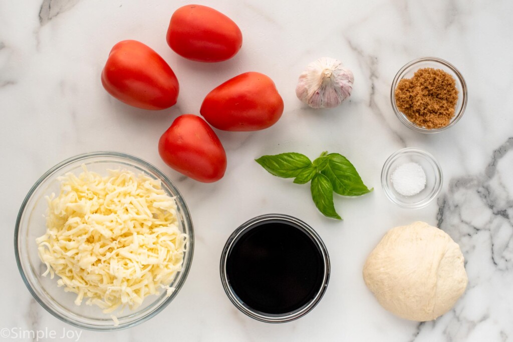 Overhead view of ingredients for Bruschetta Pizza recipe on countertop.