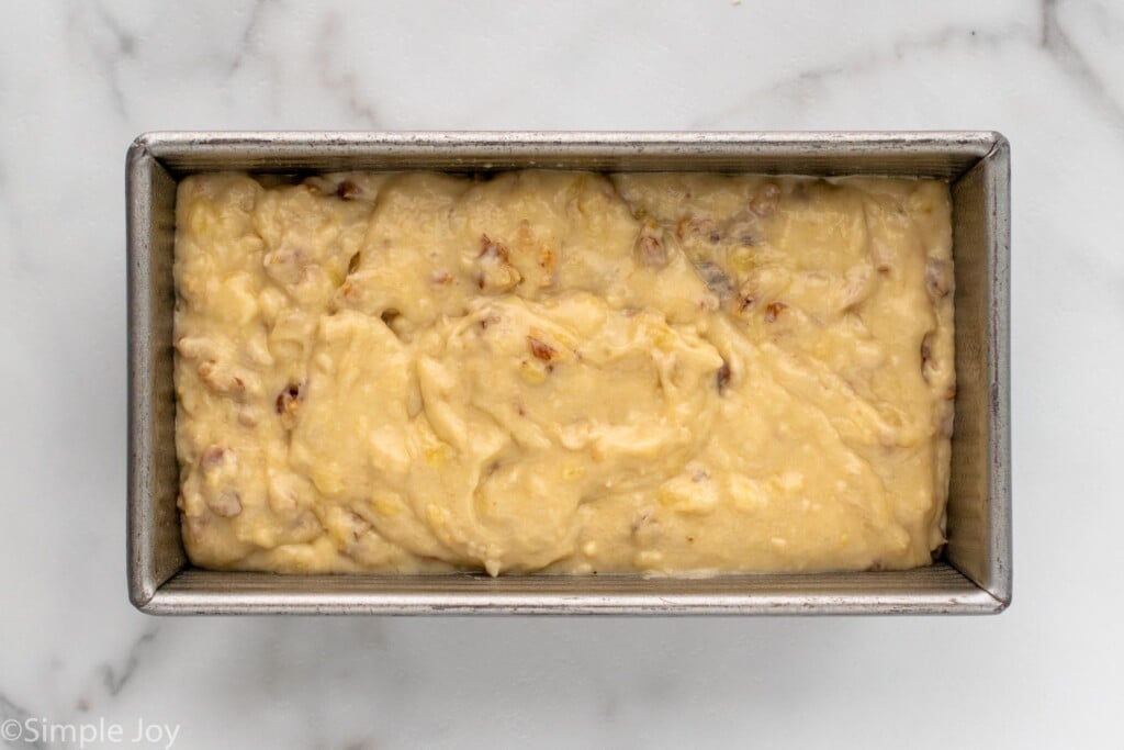 Overhead view of a loaf pan of batter for Banana Nut Bread recipe before baking.