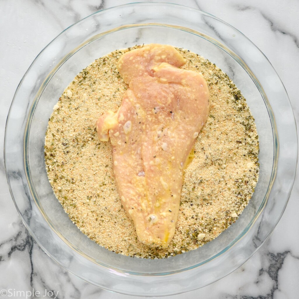 chicken breast with egg coating in a breading mixture for a chicken parmesan sandwich