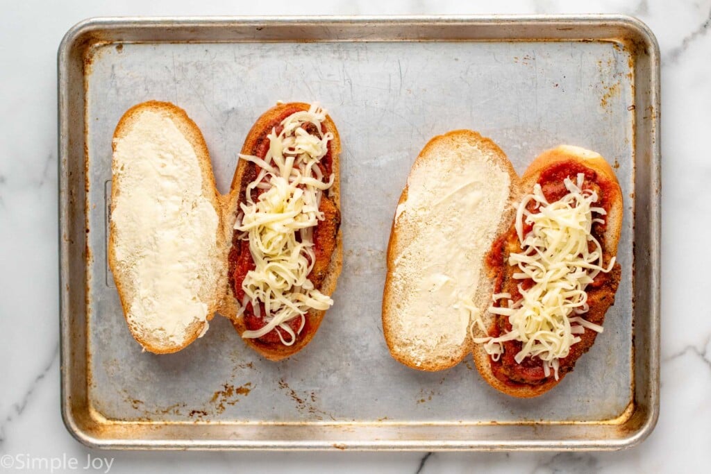 assembled chicken parm sandwiches on a rimmed baking sheet before broiling - 7