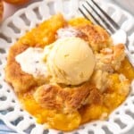 Plate of peach cobbler with scoop of ice cream on top and fork beside. - 17