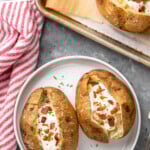 Pinterest graphic for baked potato recipe. Text says, "the best baked potato simplejoy.com." Image is overhead view of a plate with baked potatoes garnished with sour cream and bacon pieces.