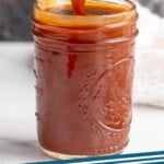 Pinterest graphic for caramel sauce recipe. Image shows a jar of caramel sauce with a spoon scooping some out. Text says, "caramel sauce simplejoy.com."