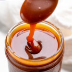 Pinterest graphic for caramel sauce recipe. Text says, "the best caramel sauce simplejoy.com." Image shows a jar of caramel sauce with a spoon scooping some out.
