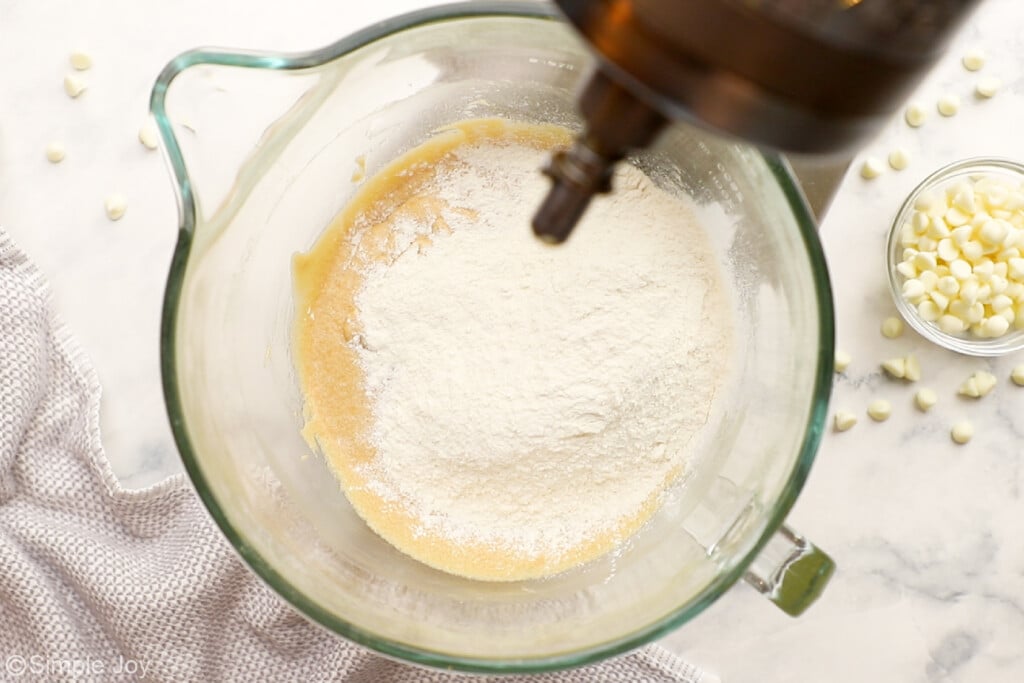 flour being added to batter in the bowl of a stand mixer