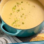 Pinterest graphic for potato leek soup recipe. Image shows pot of potato leek soup garnished with pepper and chopped green onions, bread beside. Text says, "potato leek soup simplejoy.com."